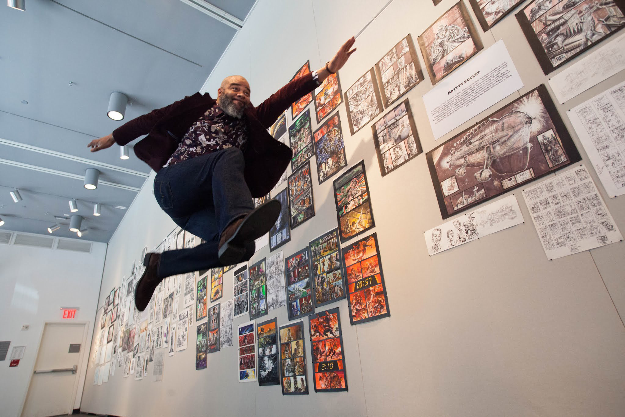 Tim Fielder jumping in front of his artwork